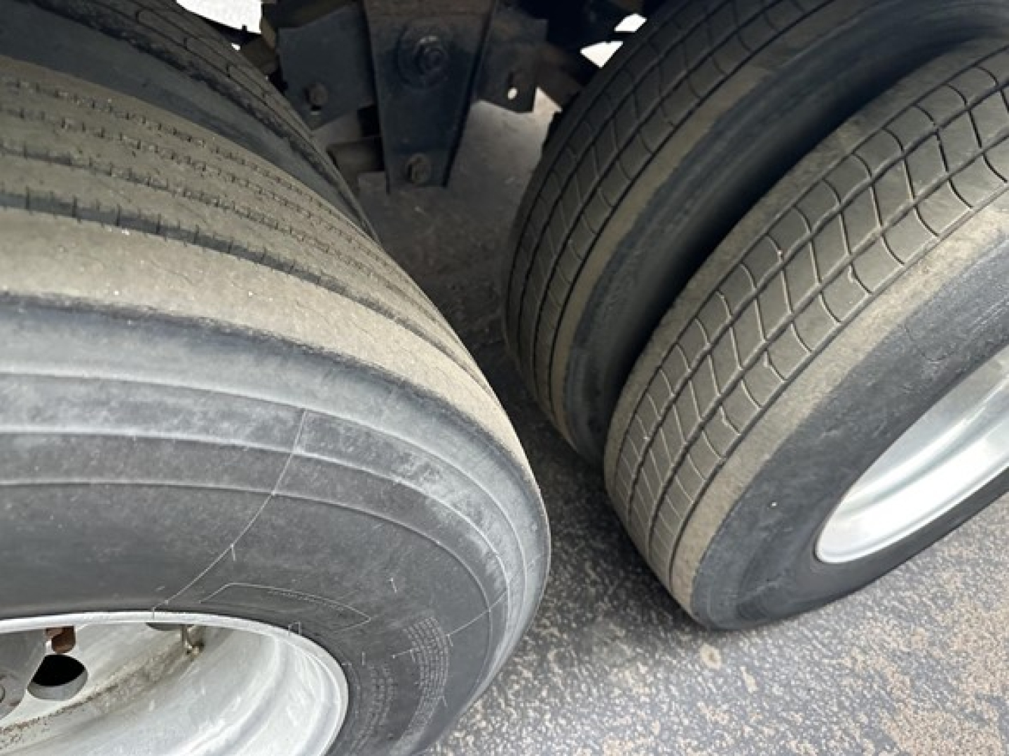Dual trailer tires and frame seen from side; no readable labels or text visible on tires or nearby components.