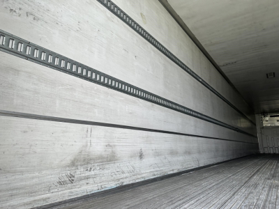 Trailer interior side wall with aluminum slat rails and ribbed floor in a reefer trailer.