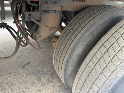Trailer dual rear wheels and undercarriage with wiring and frame components visible.