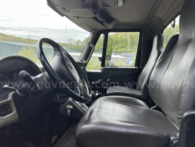 Truck cab interior showing steering wheel and black seats in a 2012 International 7400 WorkStar dump truck.