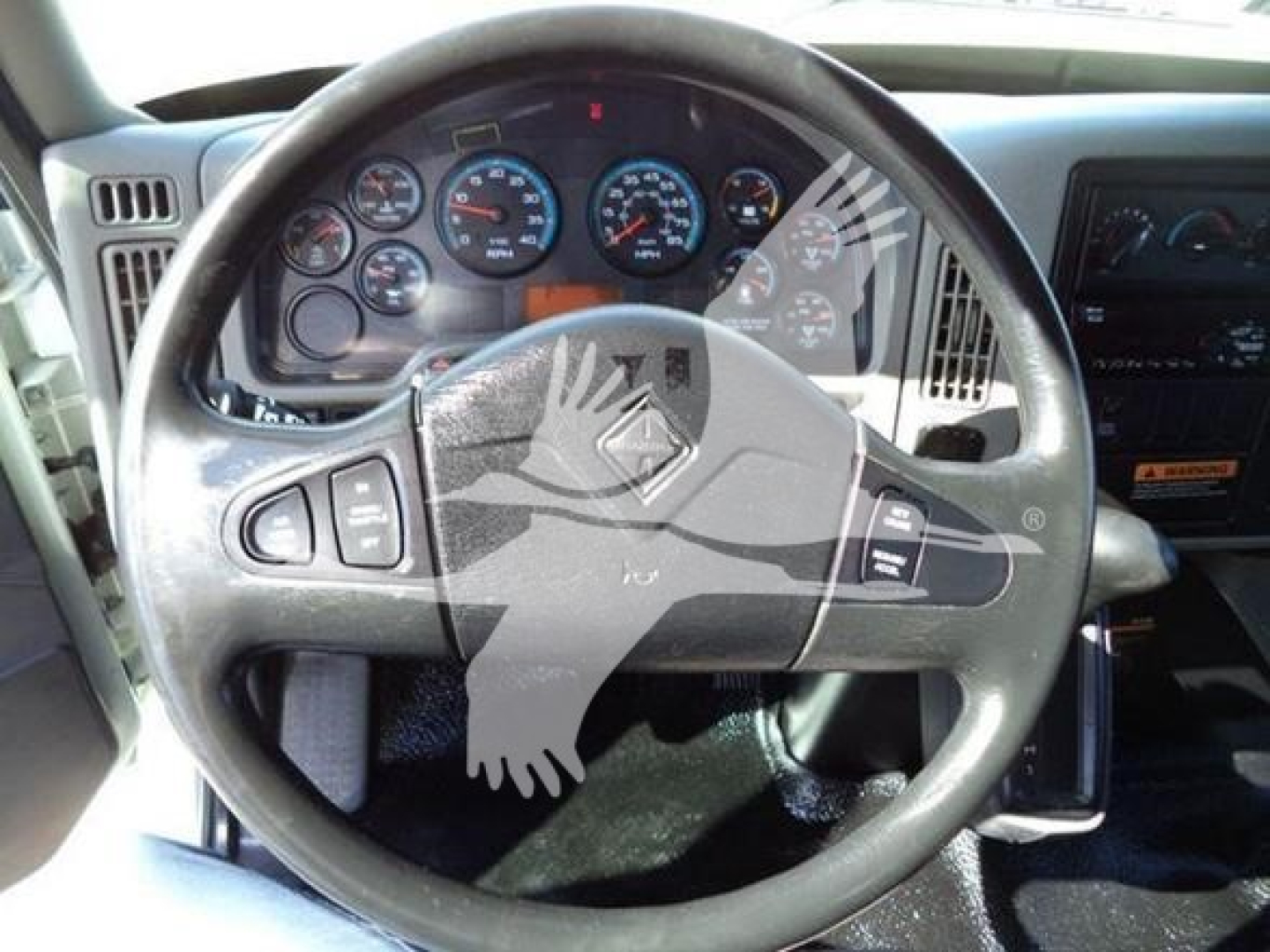 Dashboard with steering wheel and instrument cluster of a 2019 International Durastar 4300 box truck interior.