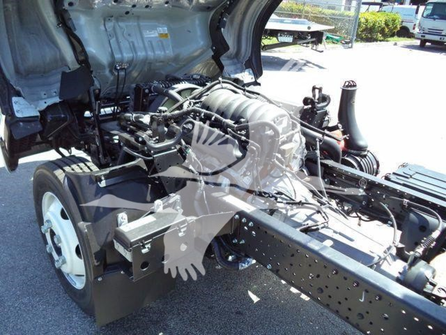 Isuzu NPR-HD truck chassis showing engine and cab wiring area with front wheel and frame rails visible.
