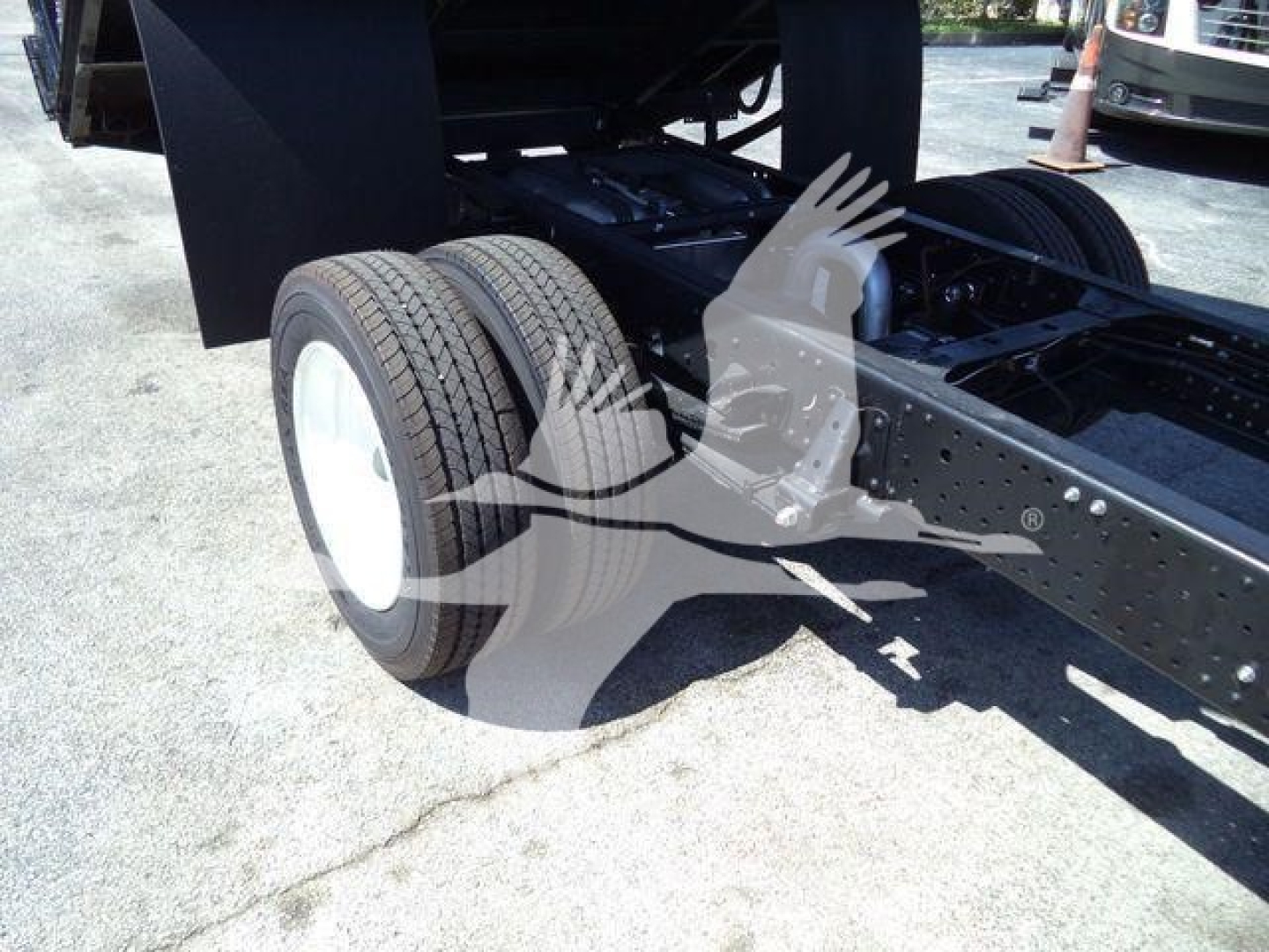 Isuzu NPR HD chassis rear showing dual rear wheels and frame with wheels and suspension components.