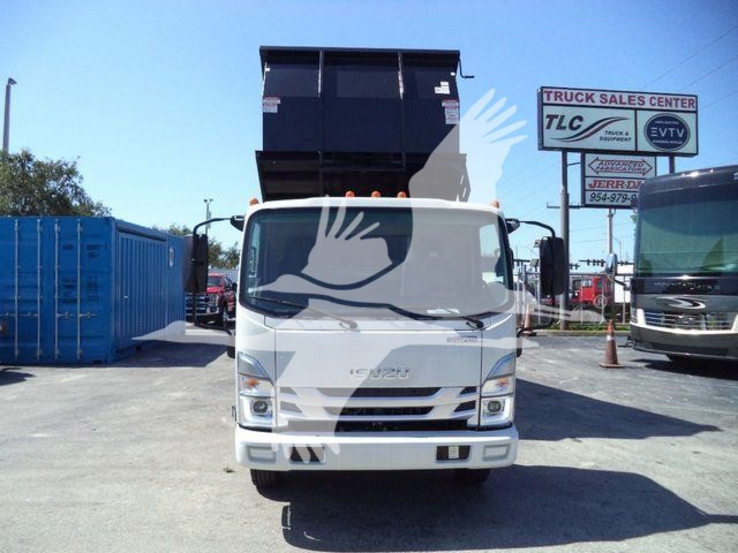 Isuzu NPR-HD truck front view with dump bed raised in dealership lot.