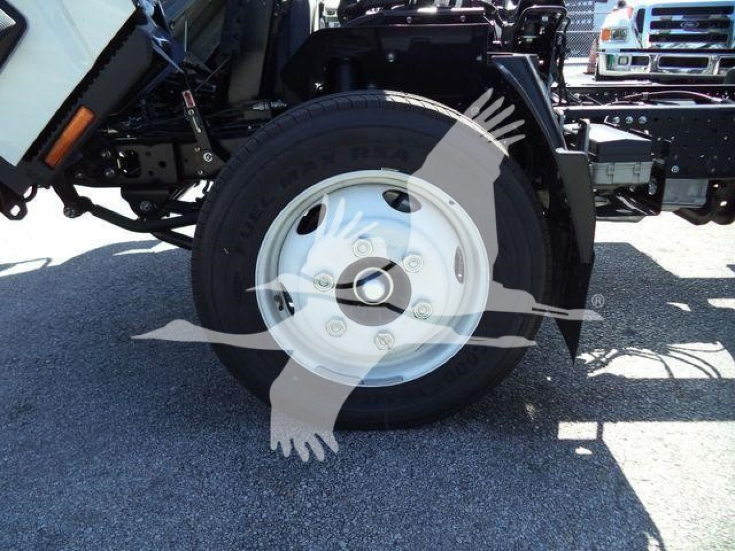 Isuzu NPR-HD truck front wheel and suspension components showing wheel, tire, and chassis.