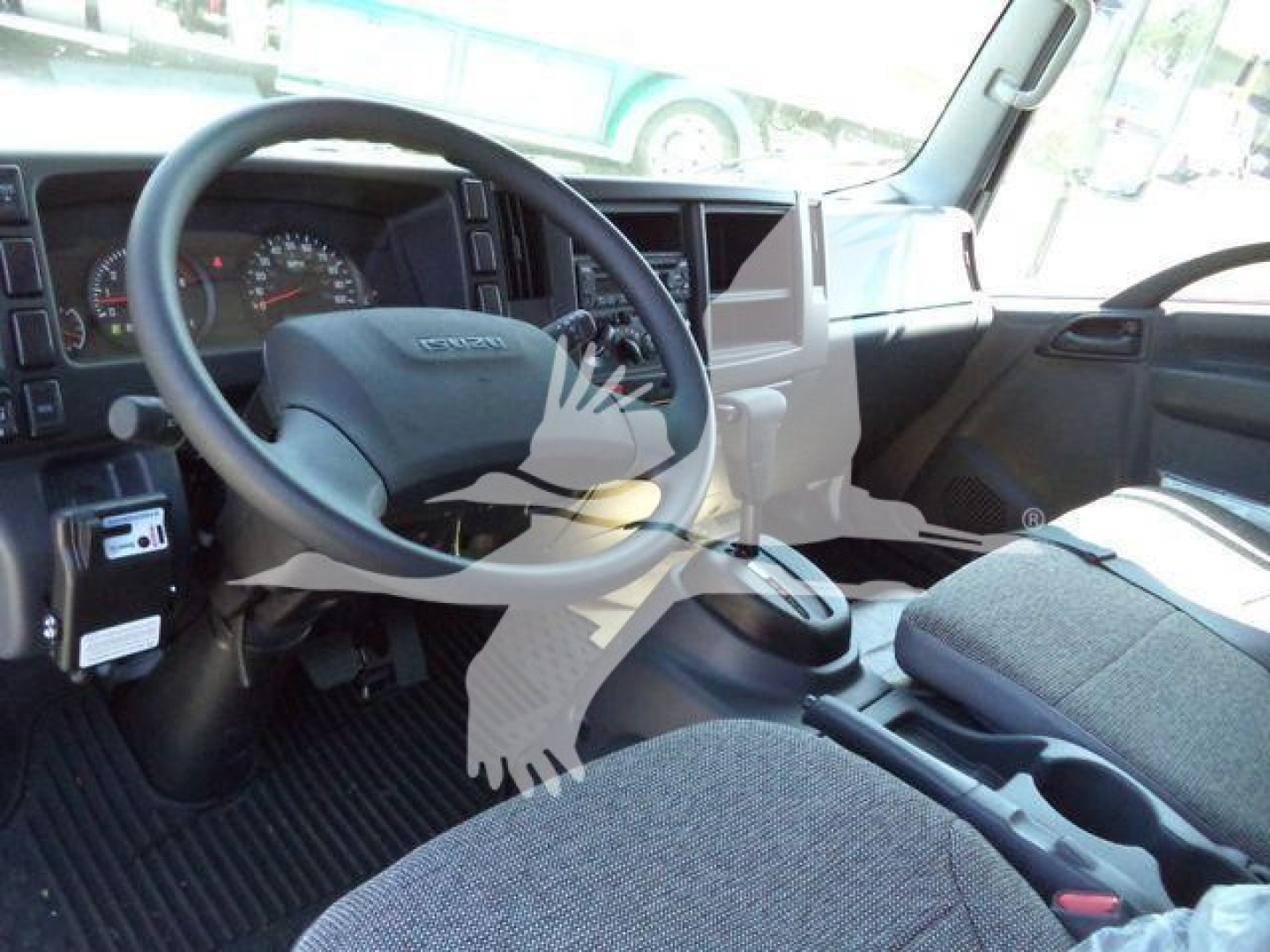 Isuzu NPR HD truck interior showing steering wheel, dashboard, and center console from driver seat angle.