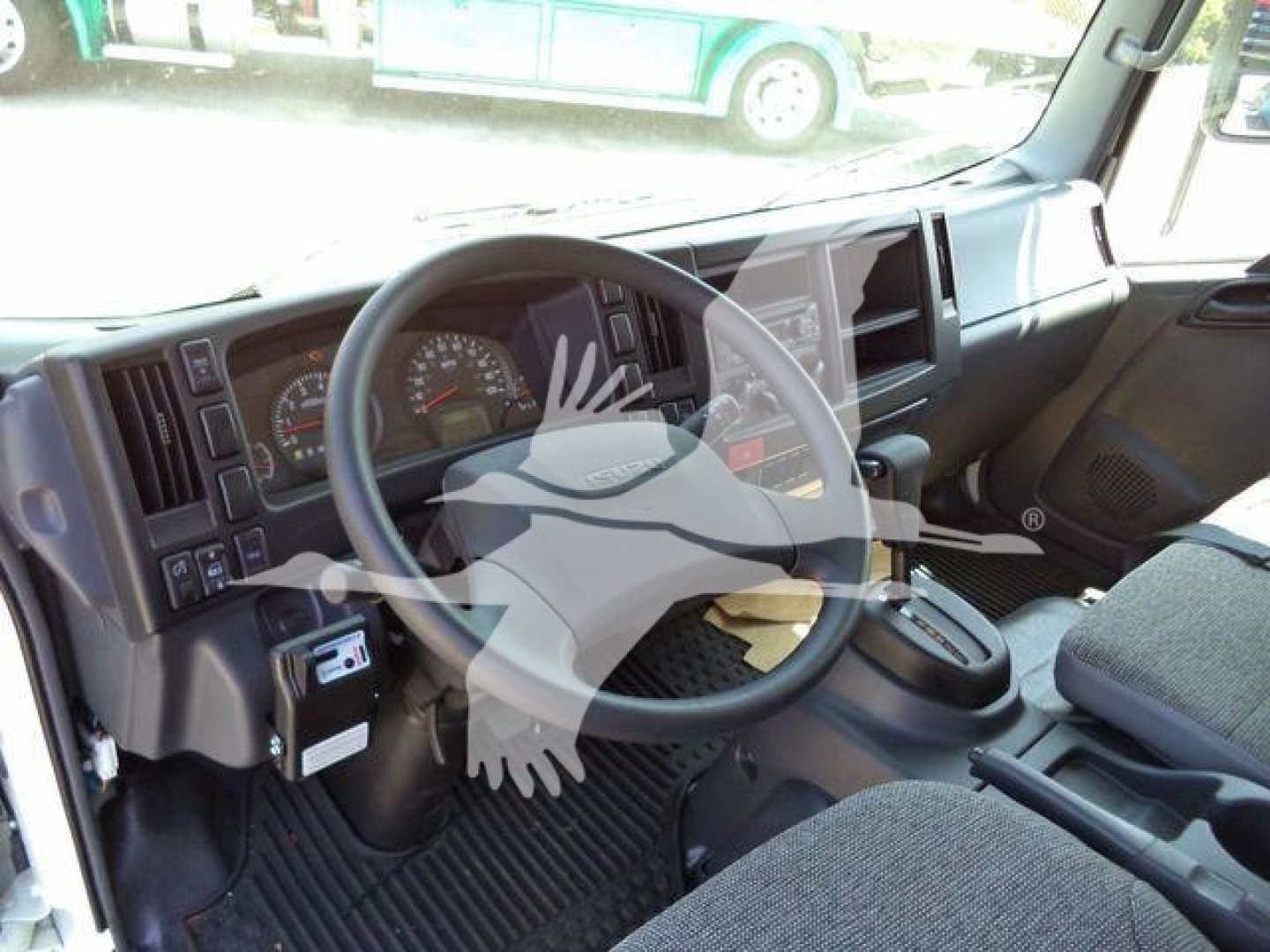 Isuzu NPR-HD truck interior driver’s cockpit with steering wheel, dashboard gauges, center console, and gear selector.