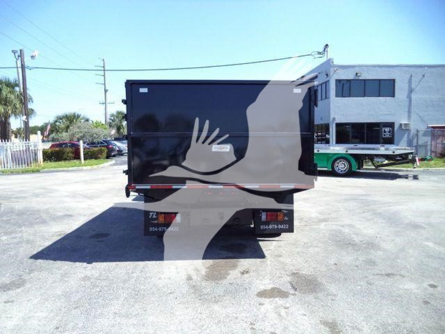 Isuzu NPR-HD truck rear view showing tail lights and bumper; black cargo body with gray graphic hand and wave design.