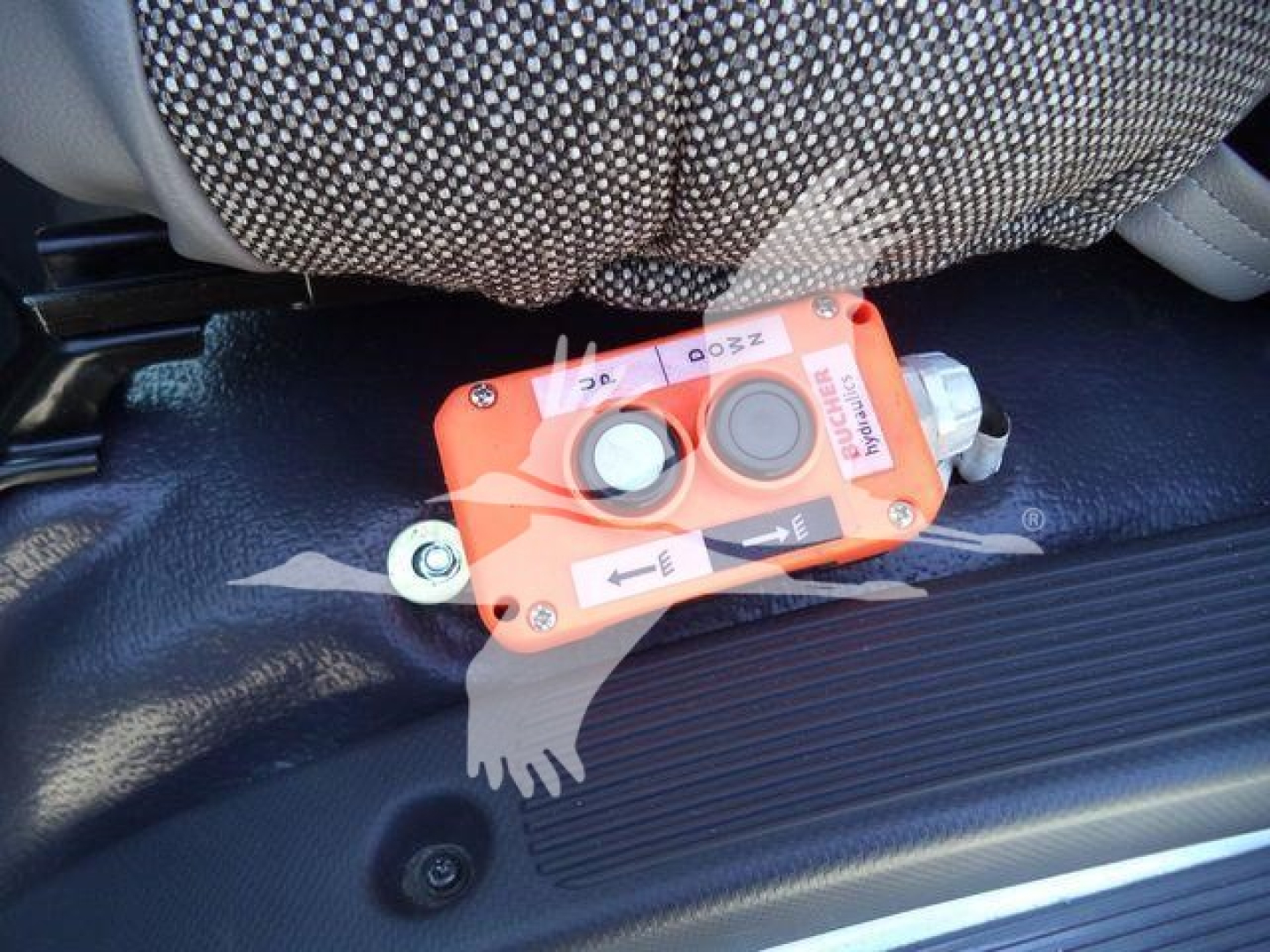 Isuzu NPR HD truck interior showing seat belt and an orange safety switch/valve with two circular caps and arrows