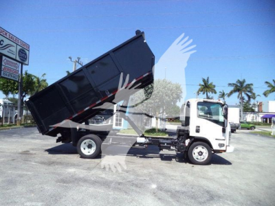 Isuzu NPR-HD dump truck in-service showing dumping bed raised on a commercial lot.