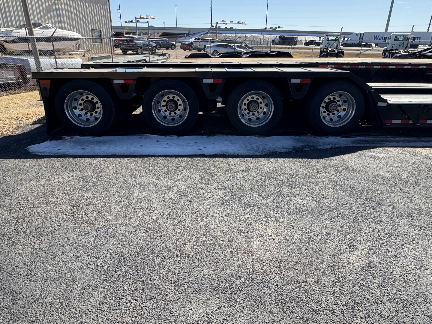 Triple-axle Load King trailer with black deck and silver wheels; no visible text readable on side in this image.