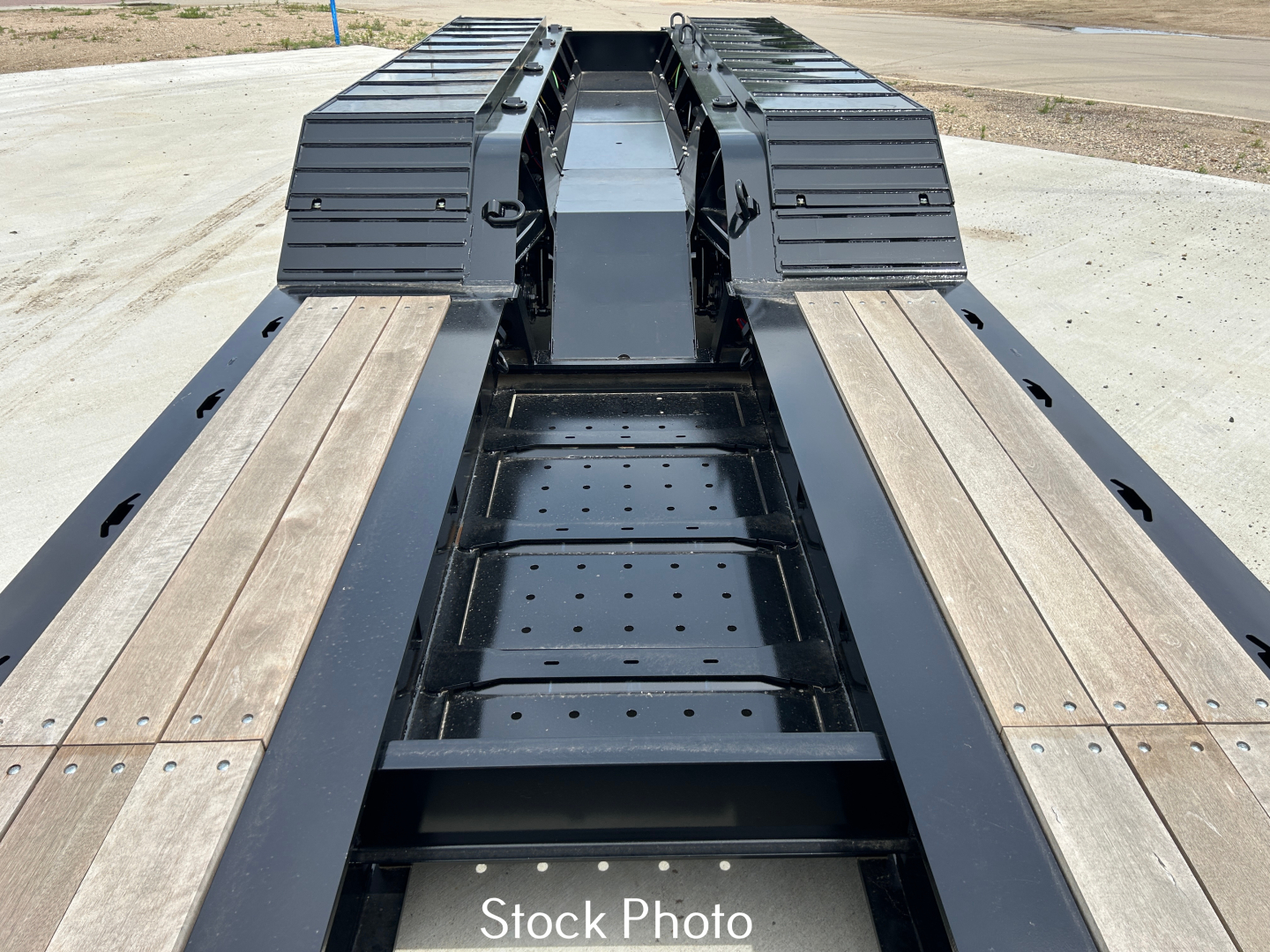 Load King trailer deck looking down center with wooden planks on sides and black metal frame.