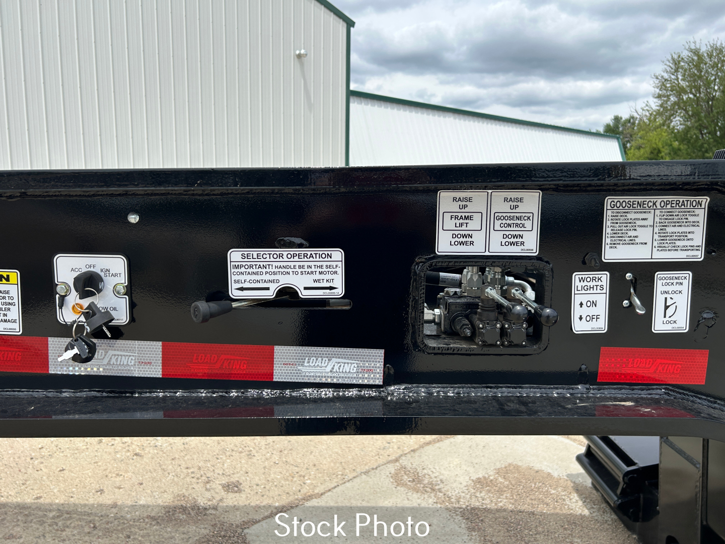 Load King trailer control labels and levers on black frame, with labels for selector operation, raise/lower, good operation, and lock mechanisms visible.