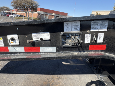 Trailer back panel with control decals and labels on Load King 554-Quad-9' Wide 24" LDH: various switches and instruction plaques, including operator labels and warning placards.
