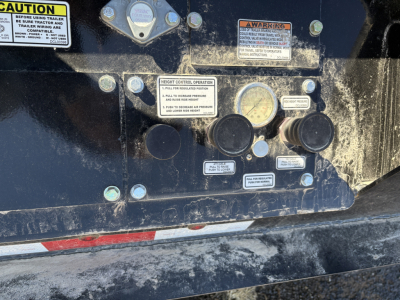 Load King trailer control panel with gauges and warning labels on a black metal surface.