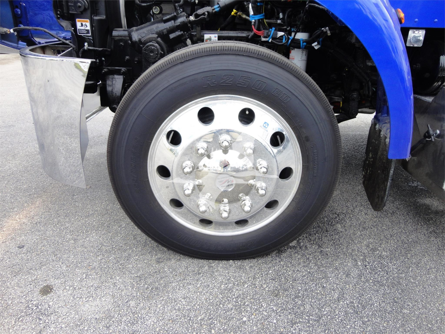 Peterbilt 337 front wheel assembly and fender shown in side view with chrome wheel, tire, and blue truck body