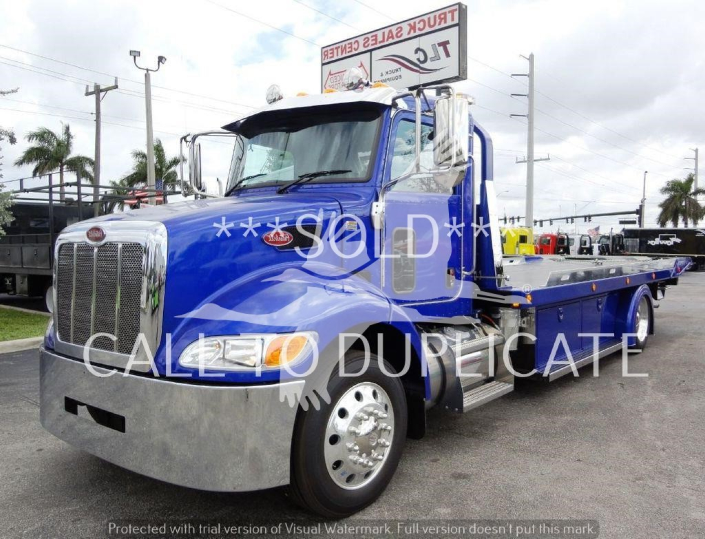 Peterbilt 337 rollback tow truck in blue with chrome bumper and flatbed, watermark text says SOLD CALLED DUREPICATE, front grille, headlight, and side mirrors visible.