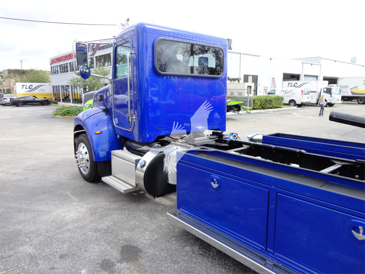 Peterbilt 337 rollback truck cab in blue with matching toolbox side compartments and chrome steps.