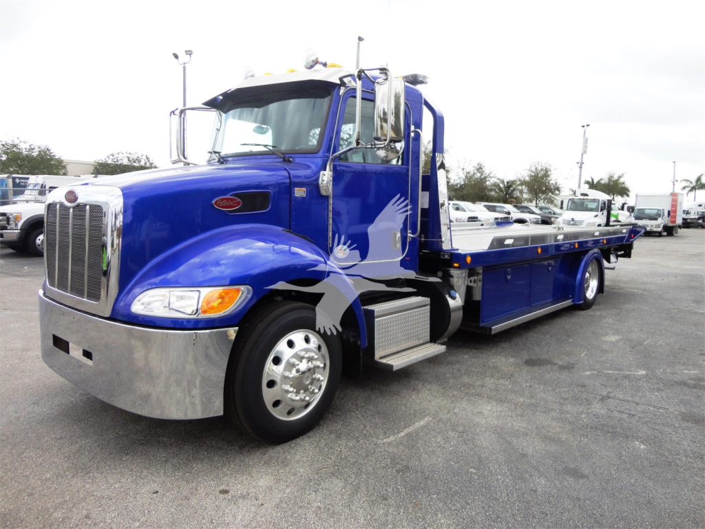 Peterbilt 337 rollback tow truck in blue, side view with chrome bumper and flatbed
