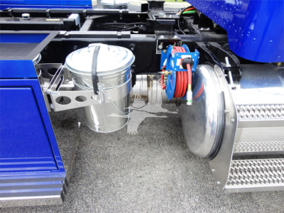 Peterbilt 337 truck chassis with blue cab, showing air reservoir, chrome air filter canister, and coiled air hoses near the front fender.
