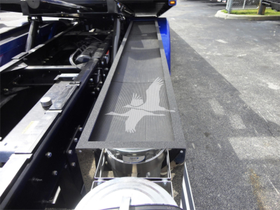 Peterbilt 337 rollback bed showing a step with a textured surface and a coiled hose reel; visible components include metal chassis and mounting hardware.
