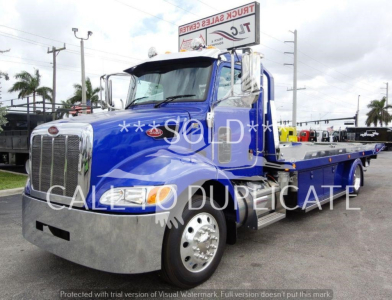 Peterbilt 337 rollback tow truck in blue with chrome bumper and flatbed, watermark text says SOLD CALLED DUREPICATE, front grille, headlight, and side mirrors visible.