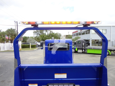 Blue Peterbilt 337 rollback truck bed with safety rails and LED light bar on top, rear view showing cargo area and transfer equipment.