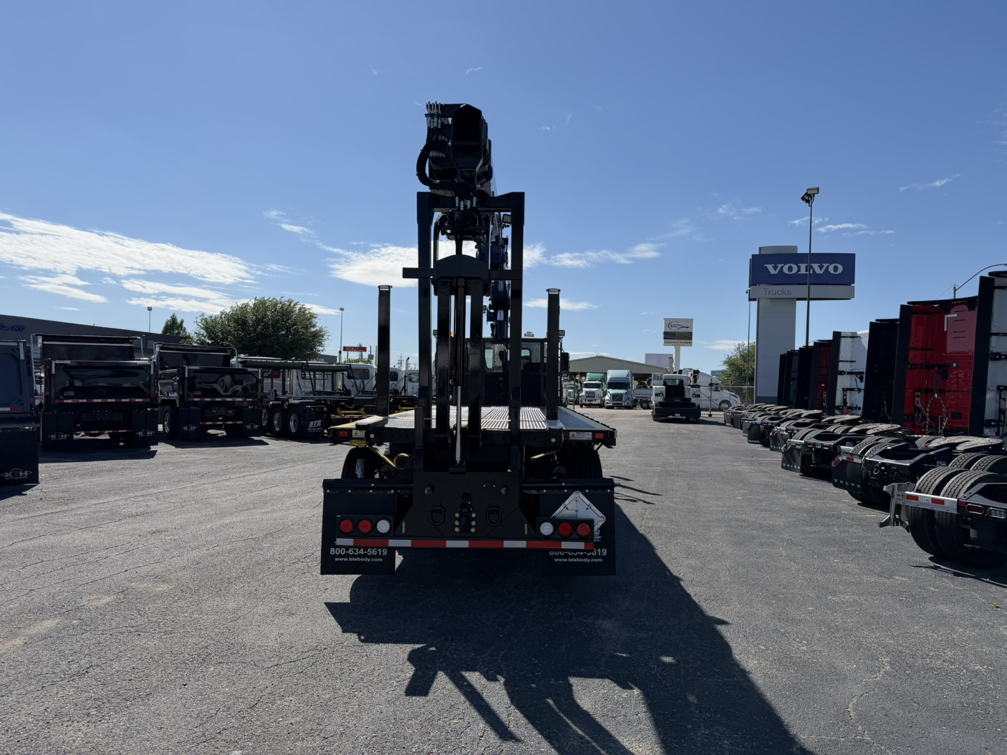 Mack GR64F crane truck rear view showing hydraulic crane and chassis with warning lights,