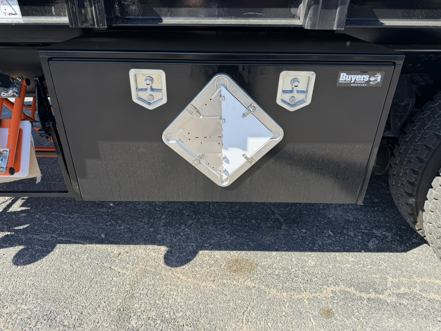 Mack GR64F crane truck rear toolbox with diamond-shaped reflective cover and two small square side panels.