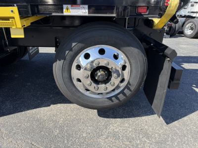 Mack GR64F truck wheel and hub assembly with chrome lug nut cover, black tire, and partial undercarriage.