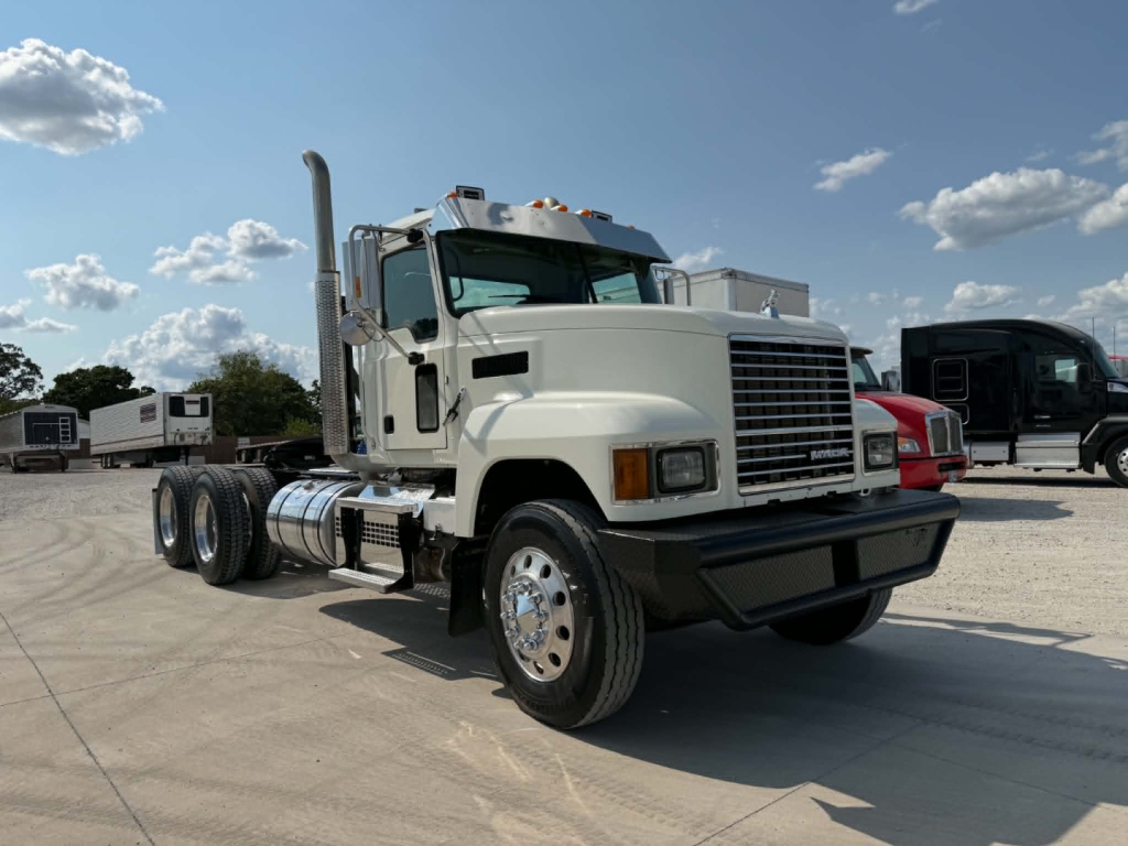 Truck front-left view of a white 2019 Mack CHU613 conventional daycab showing front grille, bumper, dual rear wheels, chrome exhaust stack, and side fuel tanks.