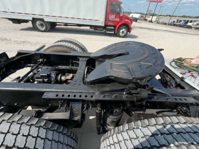 Chassis view of a 2019 Mack CHU613 cab-over truck showing rear frame with dual rear axles and circular spare wheel carrier.