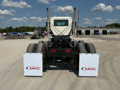 Rear view of a 2019 Mack CHU613 daycab tractor showing dual rear axles, mud flaps with MHC logos, exhaust stacks, and fifth-wheel area.