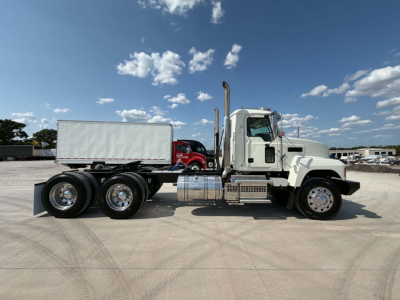 Side view of a 2019 Mack CHU613 conventional daycab truck showing dual rear axles, cargo trailer, and chrome exhaust stacks.