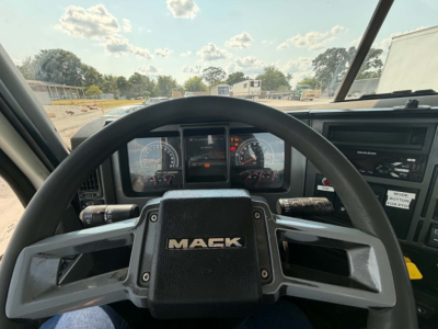 Mack CHU613 steering wheel and dashboard view inside cab showing Mack emblem on the steering wheel, gauges, and truck controls.