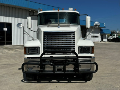Front view of a white 2020 Mack PI64T conventional day cab truck with a heavy-duty grille guard, large bumper, and rectangular headlights.