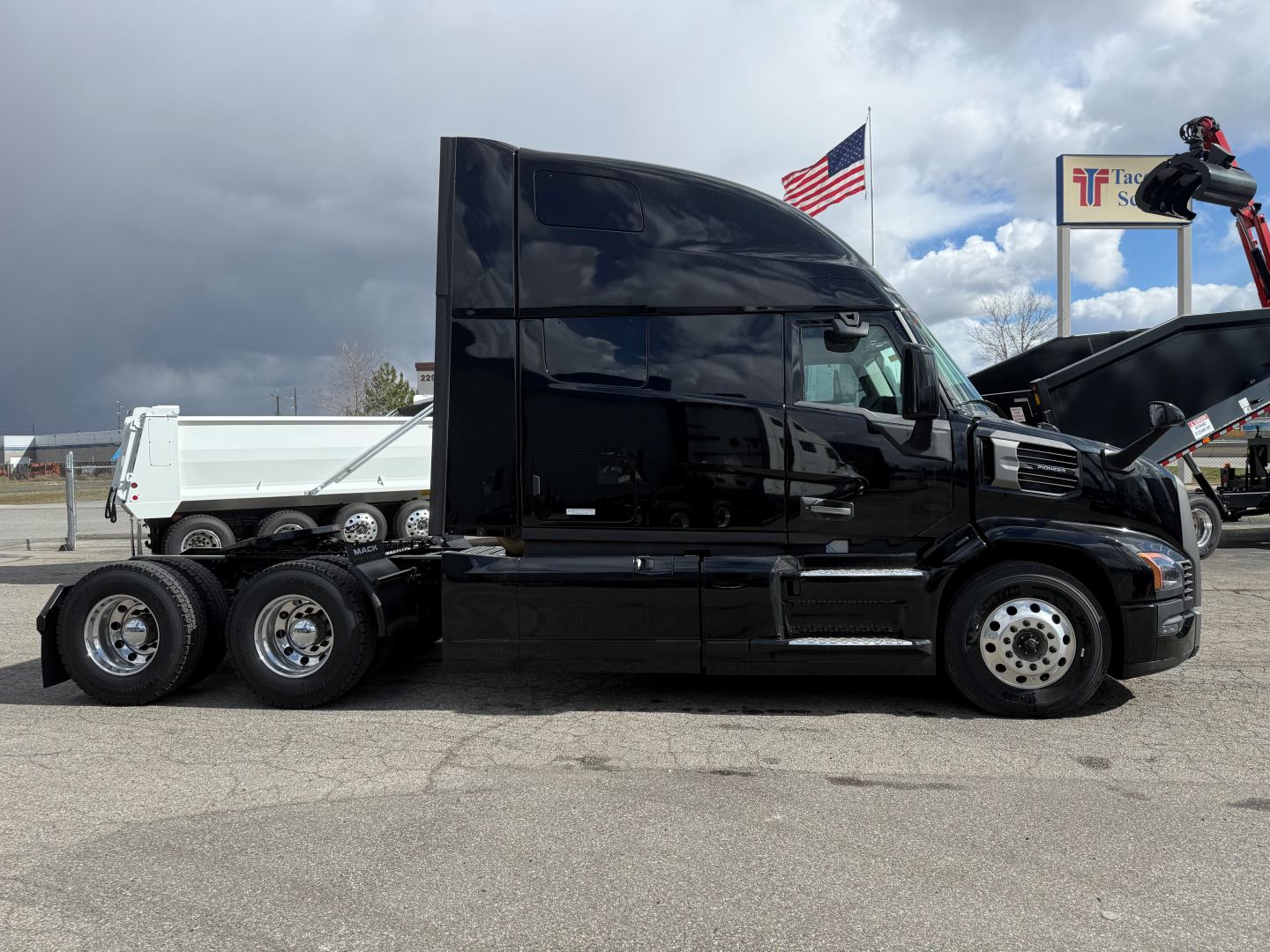 Truck side view showing a black 2026 Mack PR64T76H tractor with sleeper cab and dual rear axles.