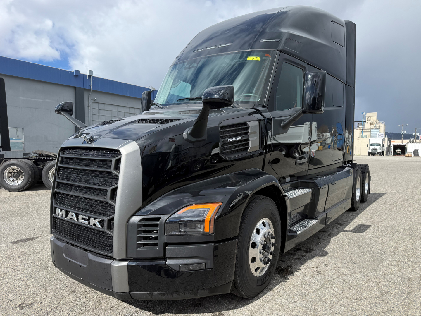 Mack PR64T76H conventional sleeper truck shown in a parking lot, glossy black exterior with silver grille and mirrors.