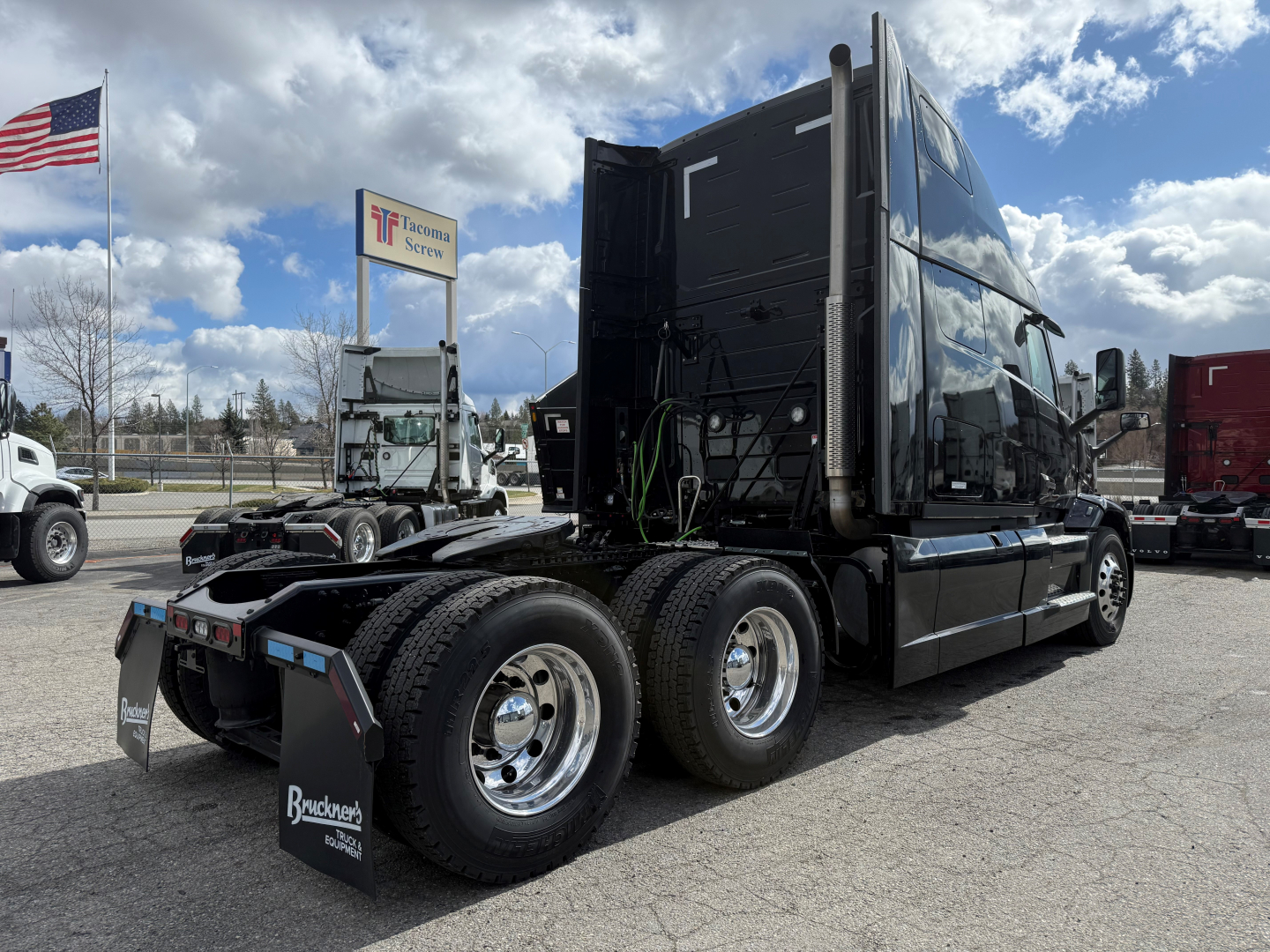 Mack PR64T76H tractor in lot showing cab and dual rear axles with chrome wheels and mud flaps.