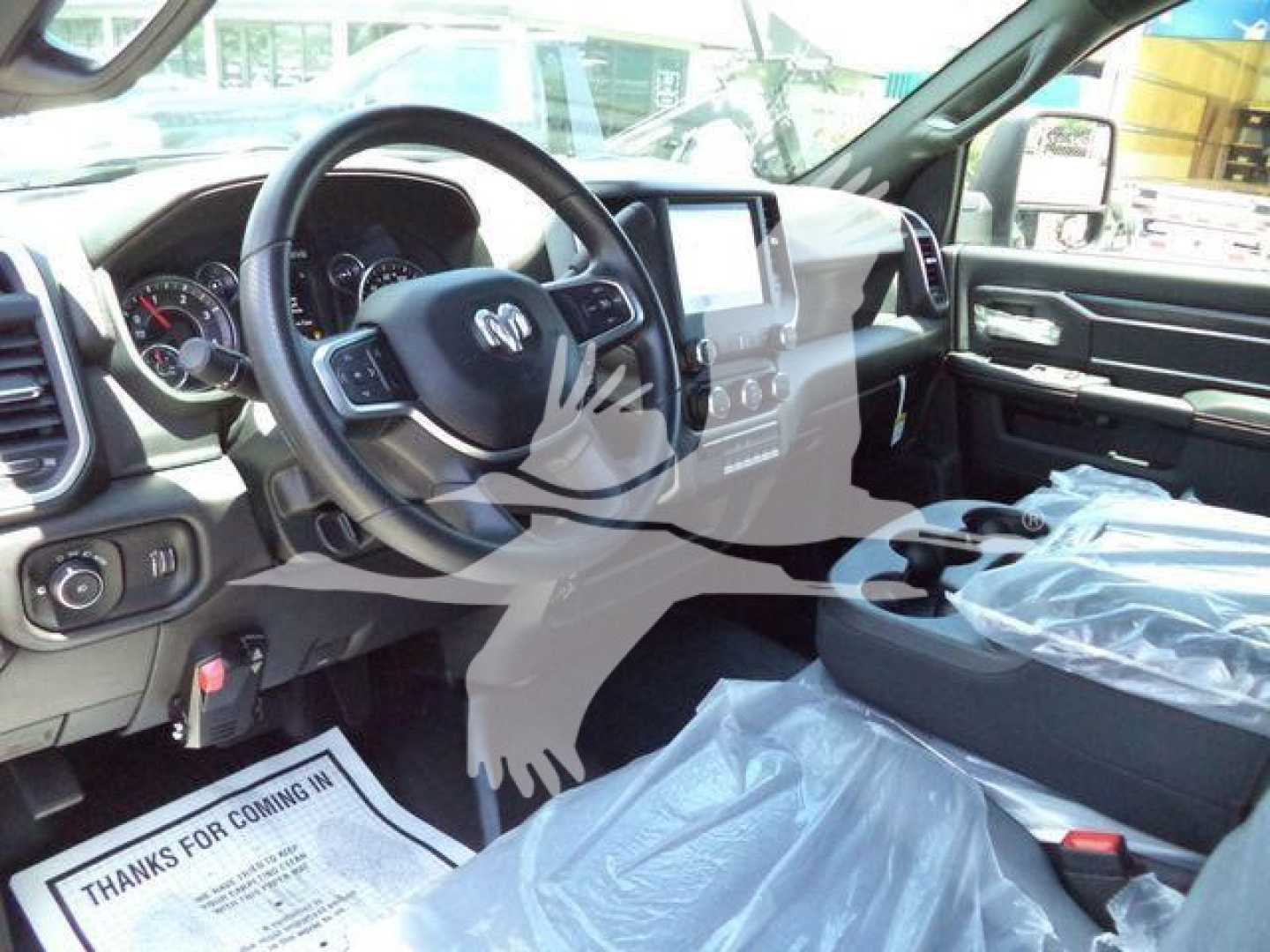 Ram truck interior showing steering wheel and center console with touchscreen display.