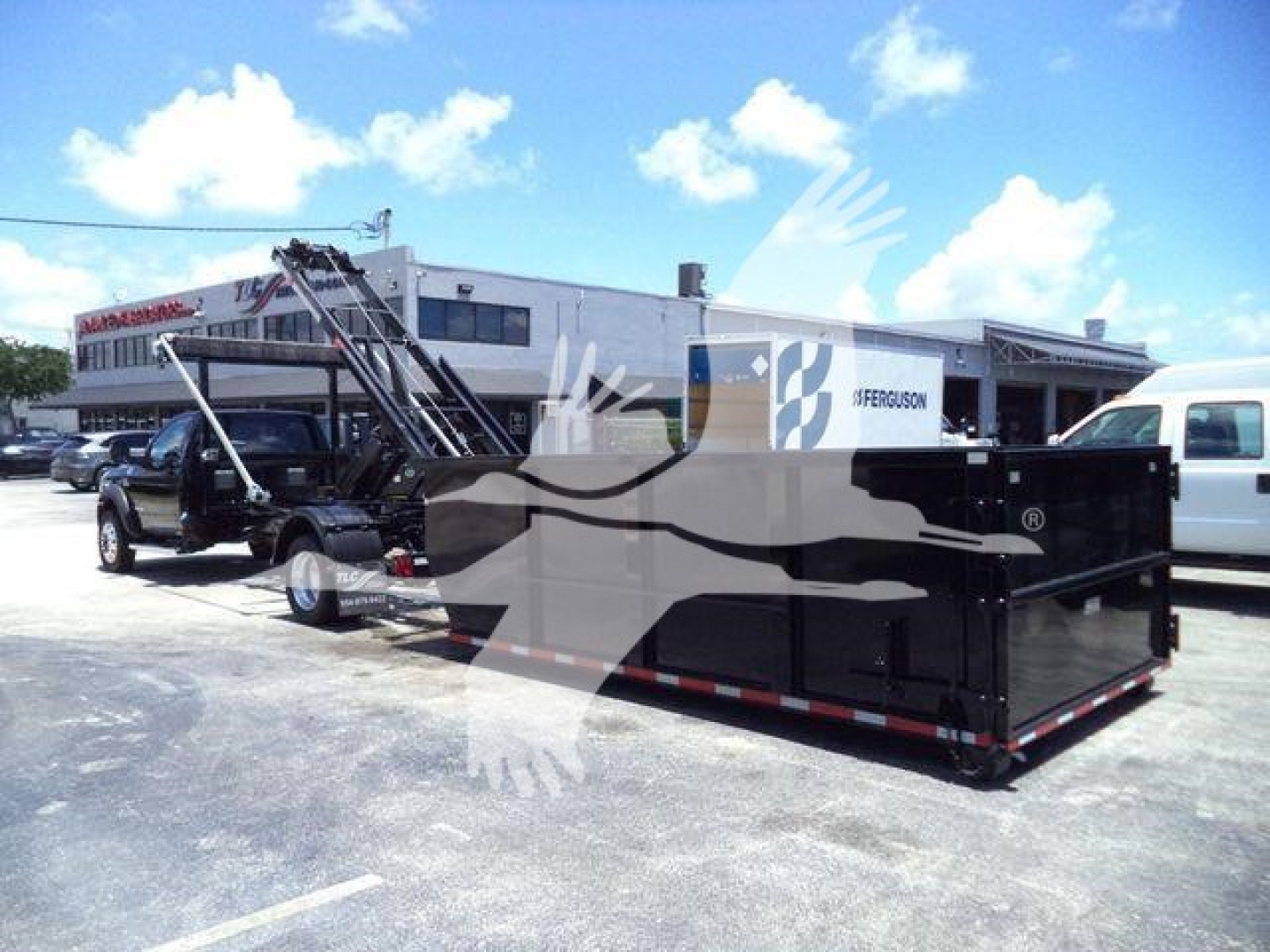 Ram 5500 SLT dump truck with roll-off container in a dealership lot.