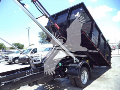 Ram 5500 dump truck bed in raised position showing hydraulic lift arms and wheel area.