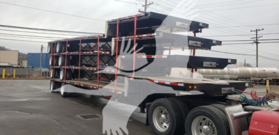 Transcraft DTL-2100 drop deck trailer stack of steel frames and ramps attached to a tractor unit.