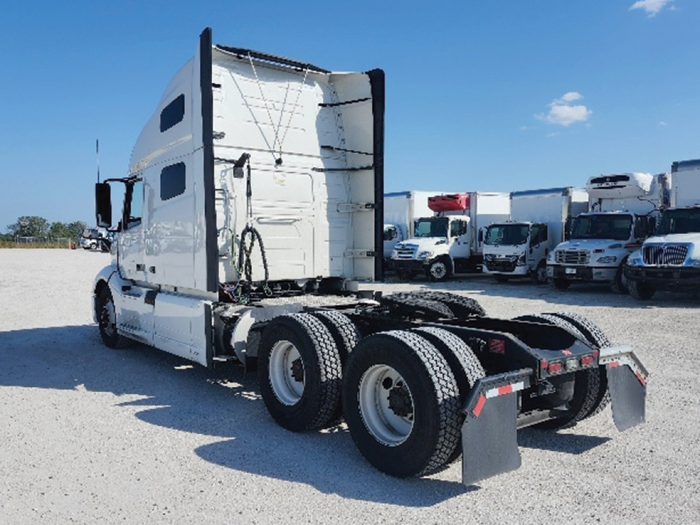 Volvo VNL 760 tractor sleeper cab rear view showing fifth wheel and dual rear axles in a truck yard.