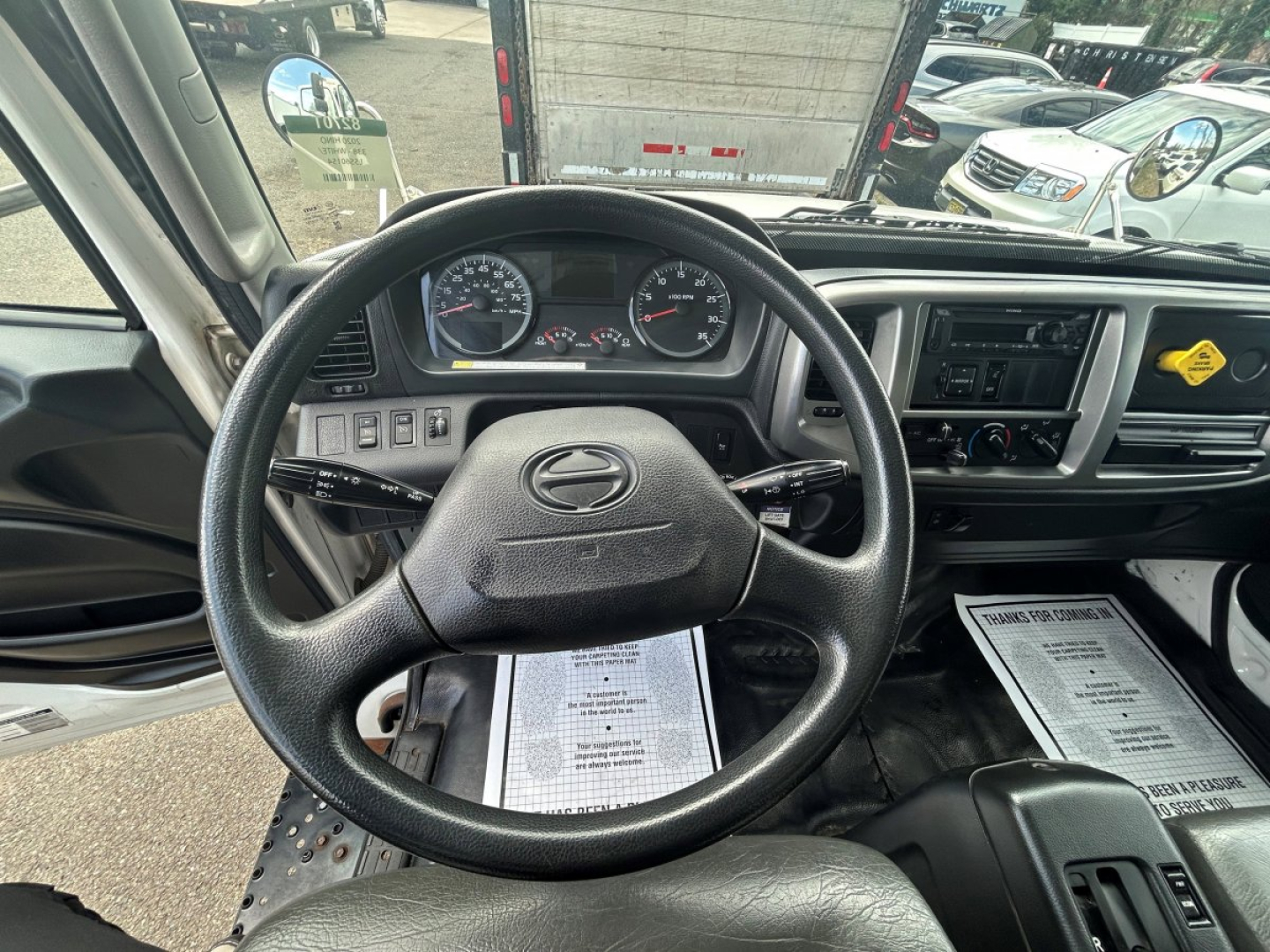 Cab interior of a 2020 Hino 338 showing steering wheel, instrument cluster, dashboard controls, and center console.