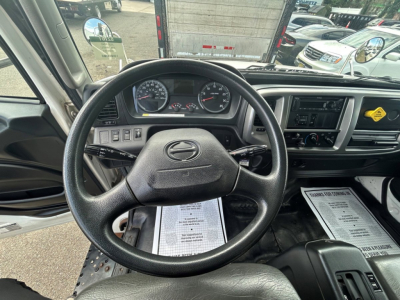 Cab interior of a 2020 Hino 338 showing steering wheel, instrument cluster, dashboard controls, and center console.