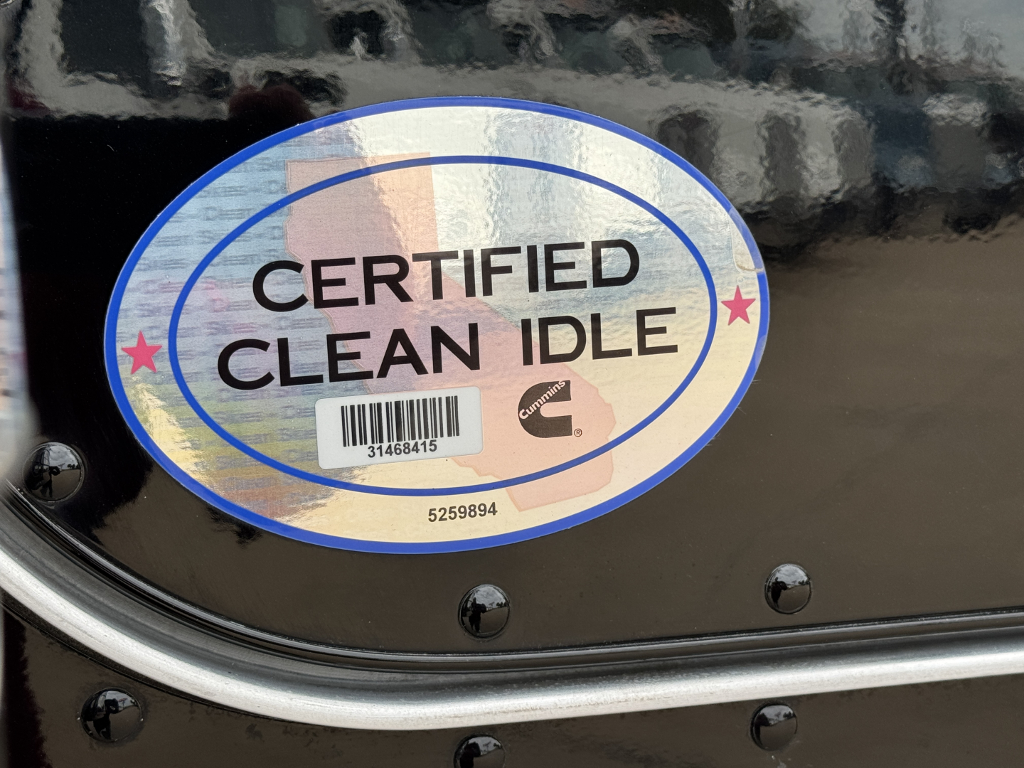 Certified Clean Idle badge on a Peterbilt 389 with reflective sticker and barcode.