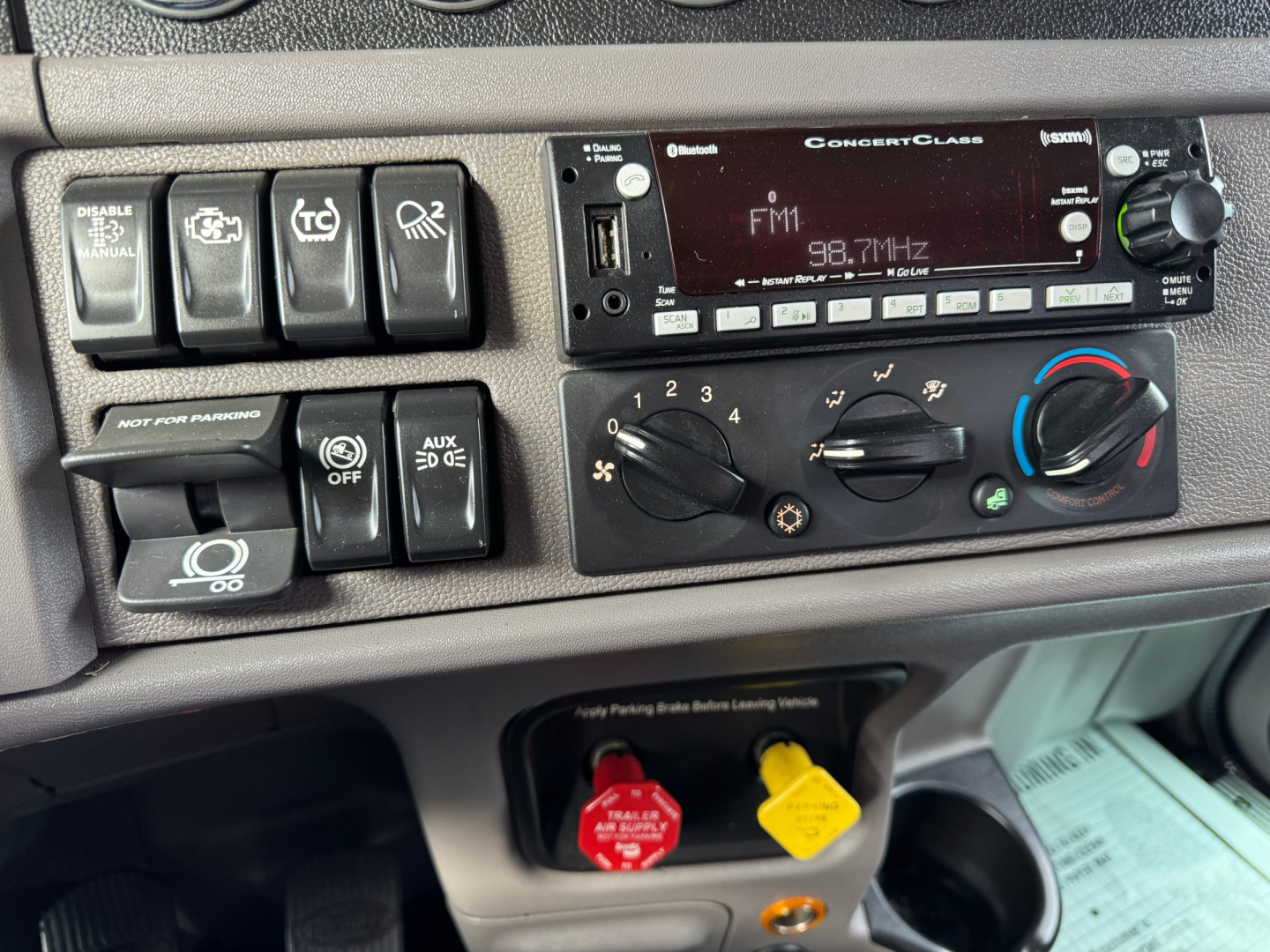 Peterbilt 389 cab interior dashboard showing climate controls, auxiliary switches, and radio display.