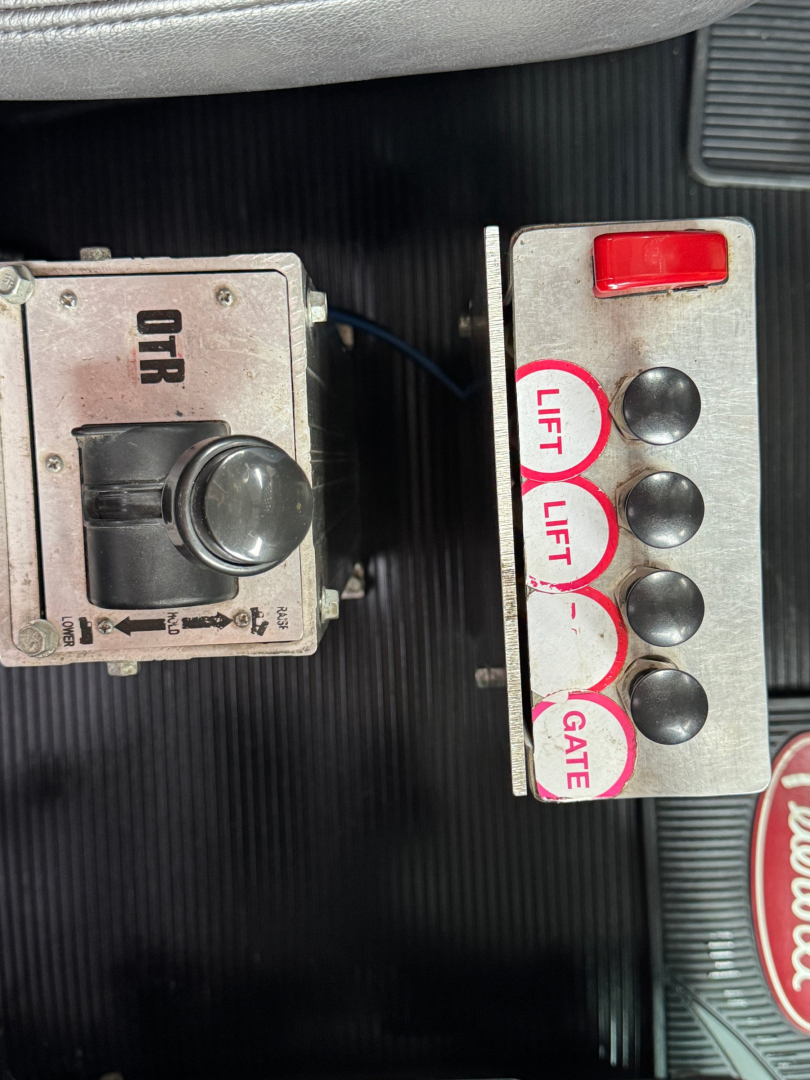 Panel of controls in Peterbilt cab showing a four-button lift/gate control with red top button and labeled lifts and gate, plus an ORR-type unit on left.