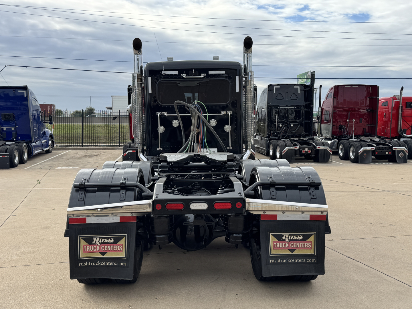 Peterbilt 389 tractor rear view showing fifth wheel and dual rear axles, with exposed air lines and wiring harnesses in the hitch area.